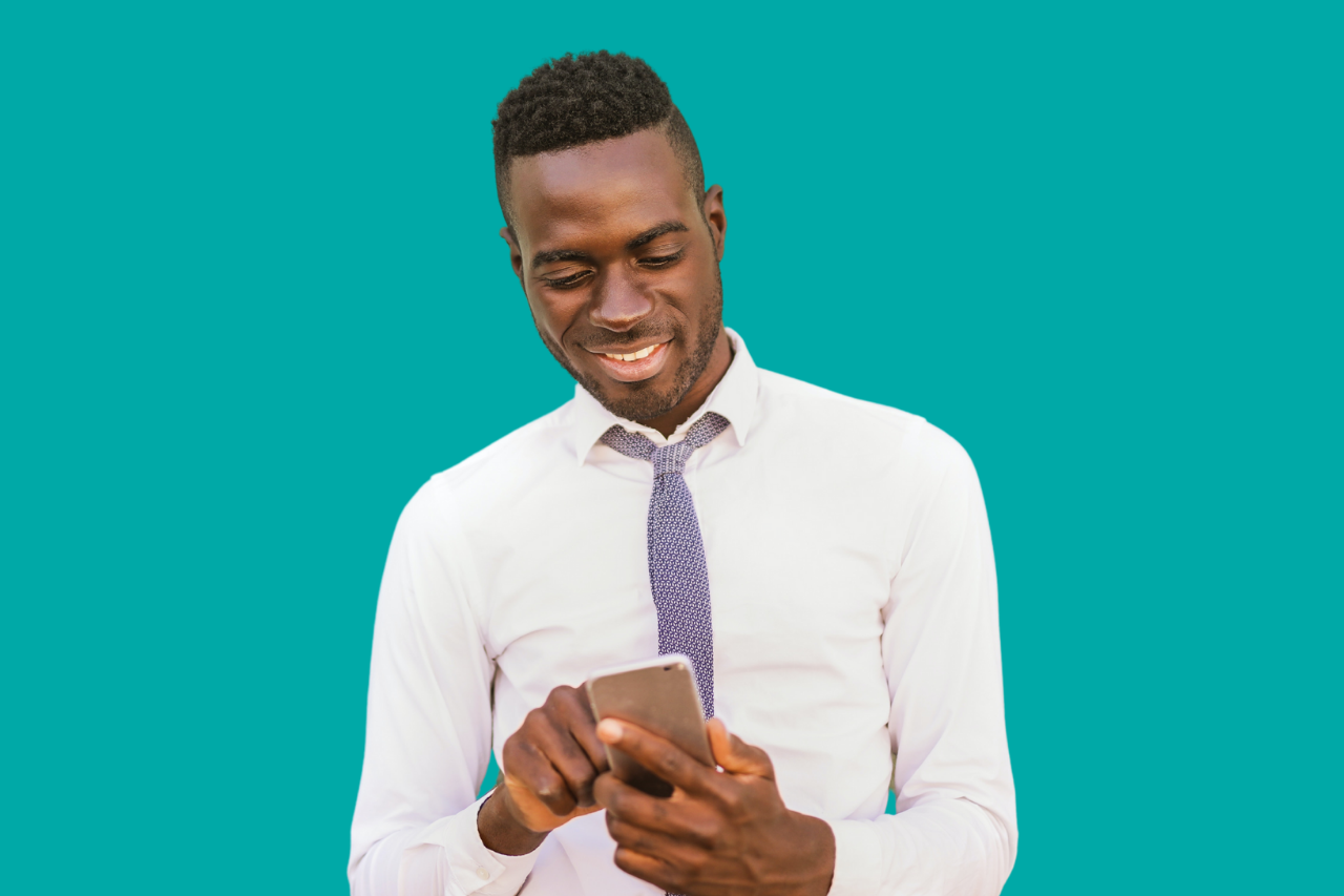 African American Man in white shirt looking down at mobile phone